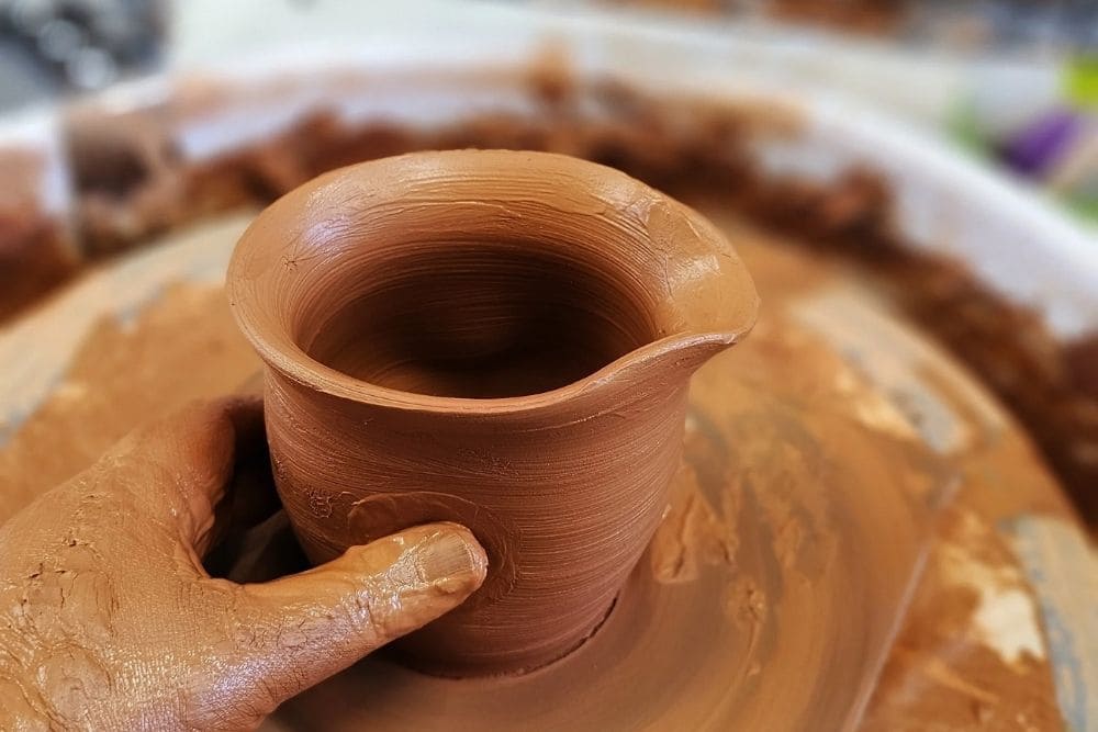 Shaping a small clay pitcher on a pottery wheel at Whistle and Page studio